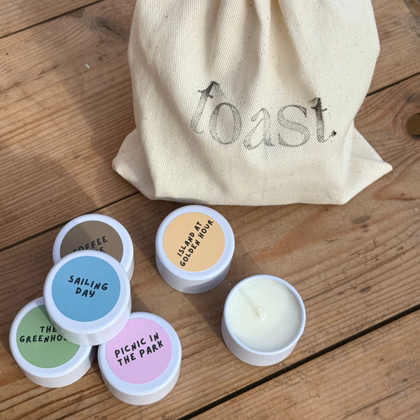 seven mini toast candles inside a branded cotton drawstring bag